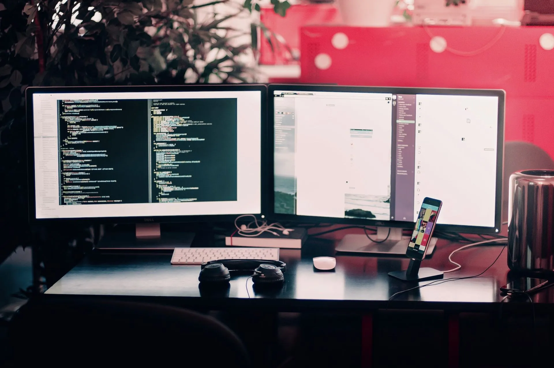 Developer desk with two monitors showing source code