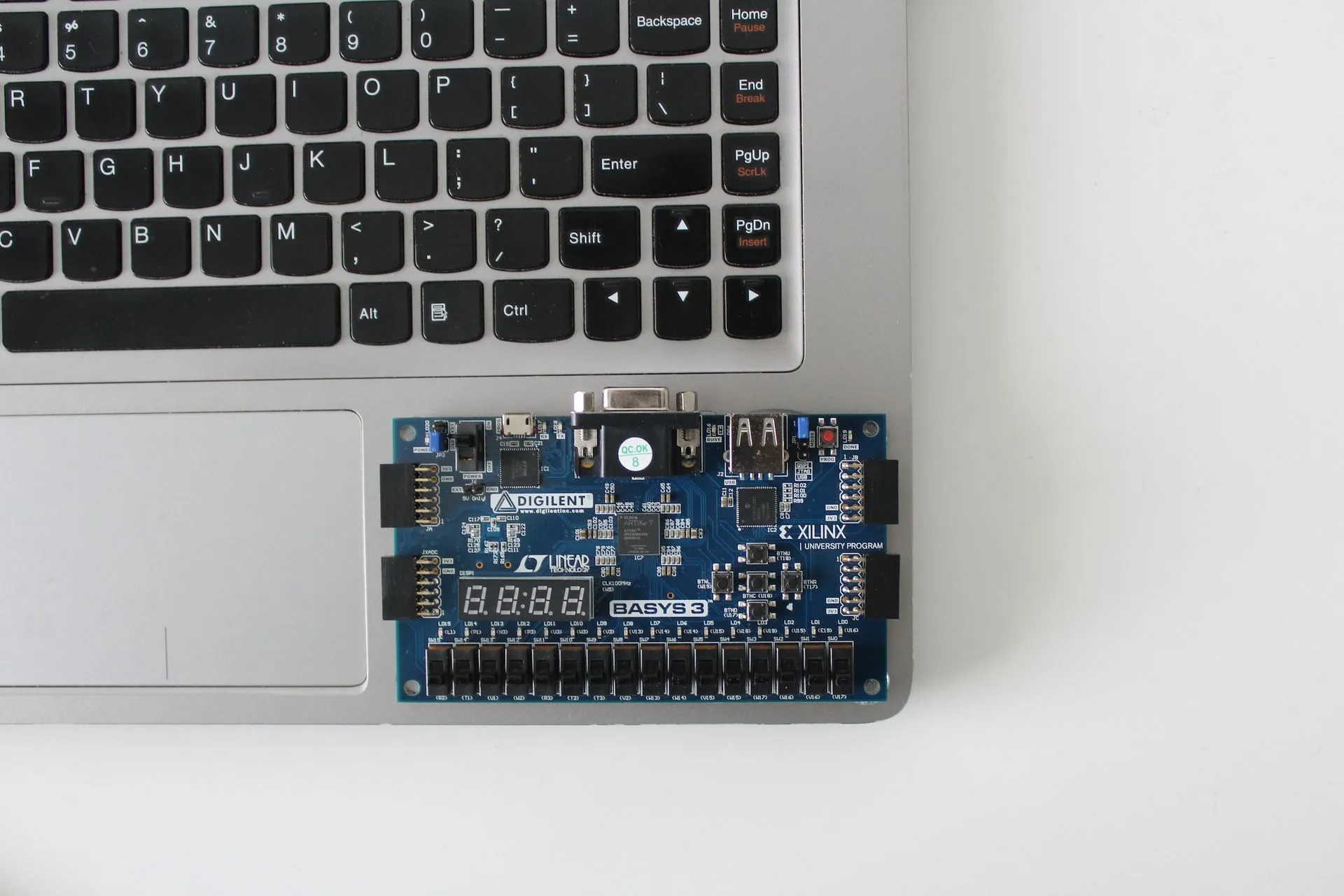 Programmable logic development board resting on a laptop keyboard